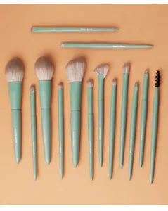 Vista dettagliata di un set di 14 pennelli da trucco verde menta con setole grigie morbide.