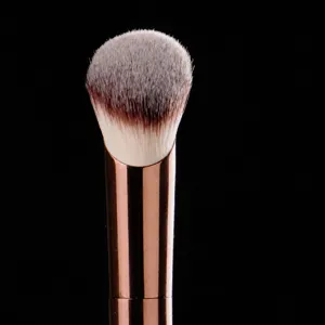 Professional angled foundation makeup brush with rose gold aluminum ferrule for flawless base.