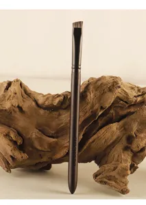 Detail shot of angled eyebrow makeup brush with fine animal hair bristles for precise filling.