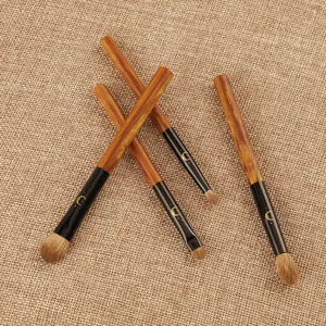Set of 4 professional eye makeup brushes with marbled brown handles and soft bristles.