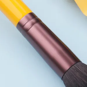 Professioneller Make-up-Pinsel mit gelbem Griff und glänzender Metallhülse für präzises Auftragen.