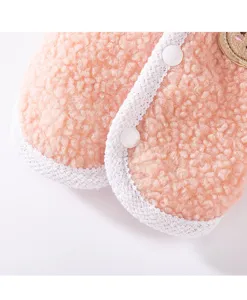 Roze teddy fleece huisdierenvest detailopname met witte bies en schattig berenborduurwerk.