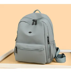 Close-up detail view of casual solid color minimalist backpack with multiple zipper pockets for daily use.