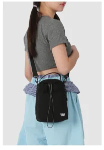 Close-up detail of the black mini crossbody phone bag with drawstring and adjustable strap.