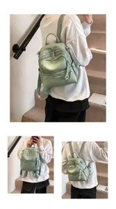 Detailed view of casual PU leather women backpack in light green with multi zip pockets.