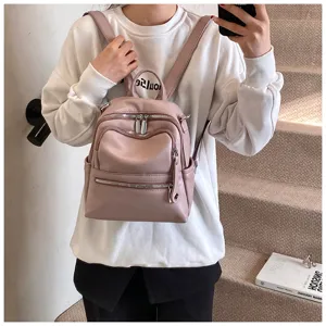 Pink PU leather casual mini backpack detail view showcasing metal zippers and front pocket.