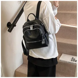 Detailed view of casual black PU leather backpack featuring multiple zipper pockets.