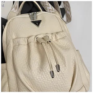 Detail view of stylish women casual backpack in beige faux leather with front drawstring.