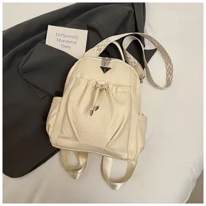 Cream leather backpack detail shot showcasing stylish drawstring pocket and wide shoulder strap.