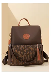 Vue detaillee du sac a dos monogramme tendance pour femme avec pompon et ecusson en cuir.