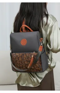 Élégant sac à dos pour femme avec motif monogrammé, poche avant zippée et bretelles.