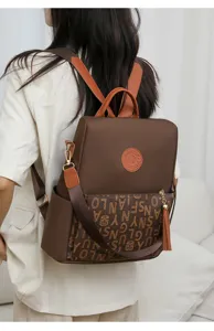 Élégant sac à dos pour femme en nylon avec poche à monogramme et charmants glands.