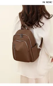 Brown nylon backpack detail showcasing multi-zipper pockets, durable fabric, and comfortable straps.