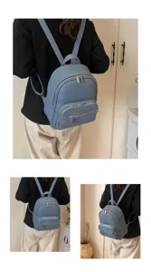 Detail view of the soft leather backpack showing multiple zipper pockets and shoulder straps.