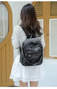 Detailed view of the casual dark grey leather backpack worn on model, showing multi-pocket design.