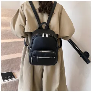 Stylish black leather backpack for women, casual minimalist design with multiple zip pockets.