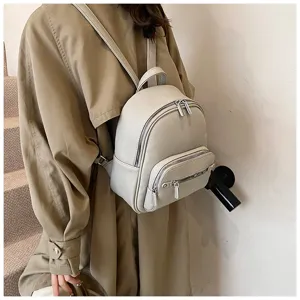 Detail view of stylish women's soft leather mini backpack worn on model showcasing design.