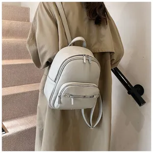 Close-up of the grey soft leather backpack worn by model, showing casual daily style details.