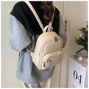 Casual soft leather backpack for women, stylish daily school bag with front zipper pocket.