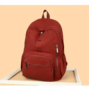 Vista dettagliata dello zaino casual rosso scuro tinta unita, con pratico design multitasche.
