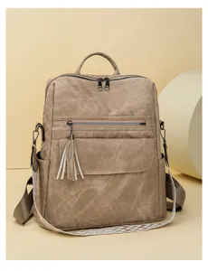Vintage soft leather women backpack with stylish tassel charm and patterned shoulder straps.