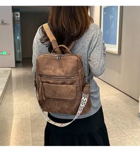 Vintage soft leather women backpack with tassel and chic ethnic strap in detail view