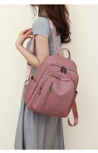 Detailed side view of women pink backpack with multiple zipper pockets and smooth straps.