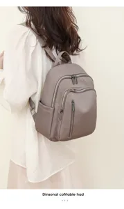 Detailed view of the multi-pocket Oxford cloth backpack, showing zippers, straps, and back fit.