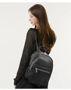 Vue detaille du sac a dos en cuir noir, avec un material texture et une fermeture eclair.
