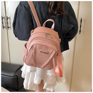 Detailed shot of a pink leather backpack worn by a model, showing daily fashion style.