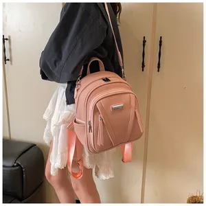 Detail view of the pink leather backpack showcasing stylish strap and multi-pocket design.