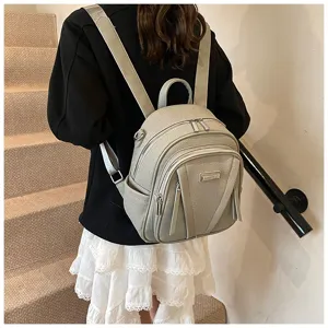 Detail view of the stylish leather backpack on model, showing multi-zipper design and straps.