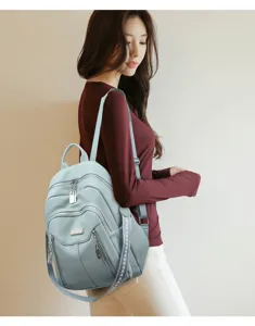 Light blue leather backpack detailed view showing multi-pocket design and quality straps.
