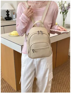 Minimalist beige leather casual backpack for women, stylish daily commute travel daypack.