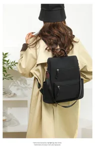Detail view of the black casual women's backpack, showing multi-compartment storage pockets.