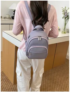 Casual purple mini backpack for women, stylish faux leather school bag with multiple zipper pockets.