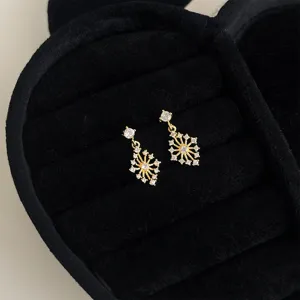 Exquisite vergoldete Zirkonia Schneeflocken Hängeohrringe Detailansicht für Damen.