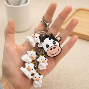Cute cartoon cow keychain with multiple mini animal charms and metal lobster clasp ring.