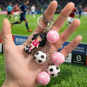 Detailed close-up of cute 3D mini soccer ball and cartoon player figurine keychain with metal ring.
