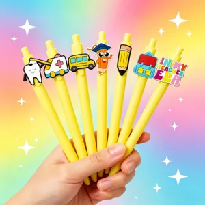 Vue détaillée de stylos à bille en plastique à pression avec breloques de dessins animés.