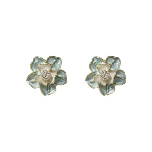 Detailed shot of elegant blue enamel flower earrings with sparkling rhinestone center and gold.