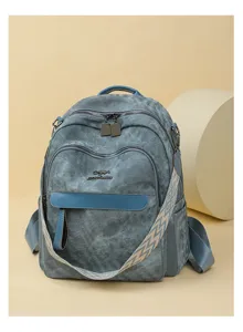 Détail du sac à dos élégant en cuir bleu-gris avec fermetures éclair et bandoulière large.