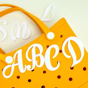 Oranje geperforeerde strandtas met witte 3D letterhangers voor een unieke DIY zomerstijl.
