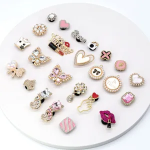 Close-up view of assorted pink alloy rhinestone and pearl shoe charms decorative details.
