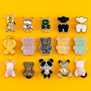 Vue détaillée de divers charms de chaussures ours en métal et strass pour sabots et accessoires DIY.