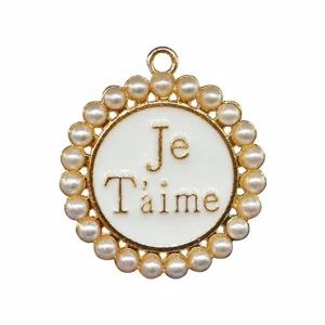 Close up detail of round metal shoe charm with pearl border and French text enamel insert.