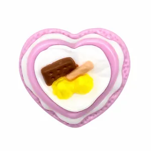 Detailed close-up of cute pink heart cake shoe charm PVC decoration accessory for clogs and sandals.