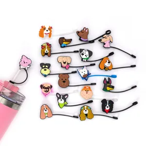Close-up view of various cute cartoon dog silicone straw covers and charms on a pink cup.