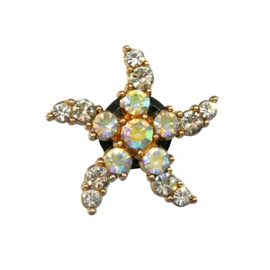 Primer plano del dije de estrella de mar brillante para zapatos con pedrería, base metálica.