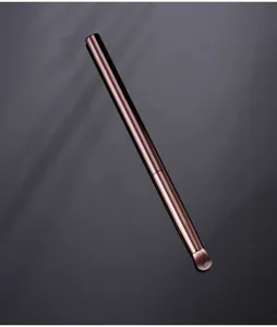 Gros plan du pinceau de maquillage à manche métallique et poils synthétiques pour un estompage précis.